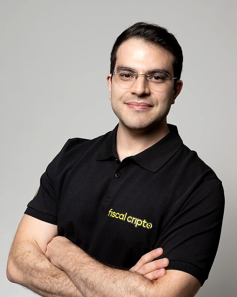 Guilherme Zamur, fundador e CEO da Fiscal Cripto, de óculos e camisa polo preta com o logotipo da empresa